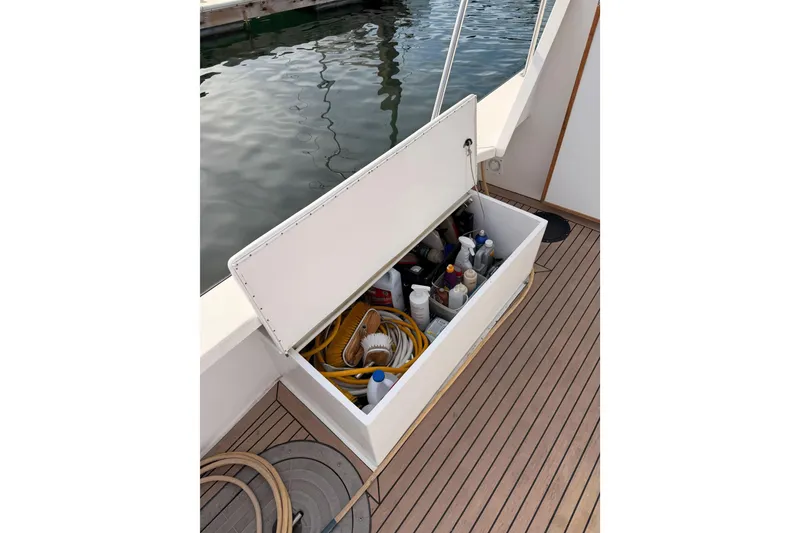 Slide: The Image of Open storage compartment on 2002 Eastern Downeast 35 boat deck, containing cleaning supplies and hoses. - 65
