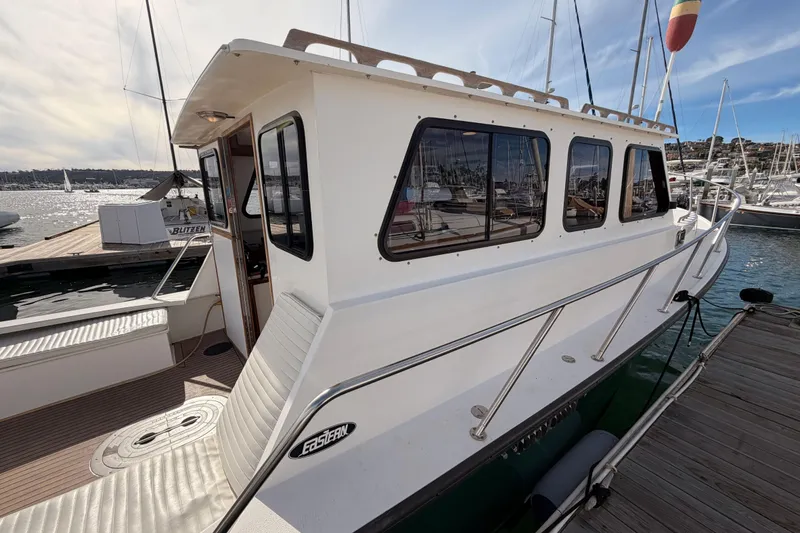 Slide: The Image of 2002 Eastern Downeast 35 boat docked at marina, showcasing cabin and deck. - 8