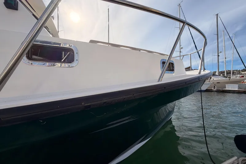 Slide: The Image of 2002 Eastern Downeast 35 boat docked in marina, side view with railing and windows. - 9