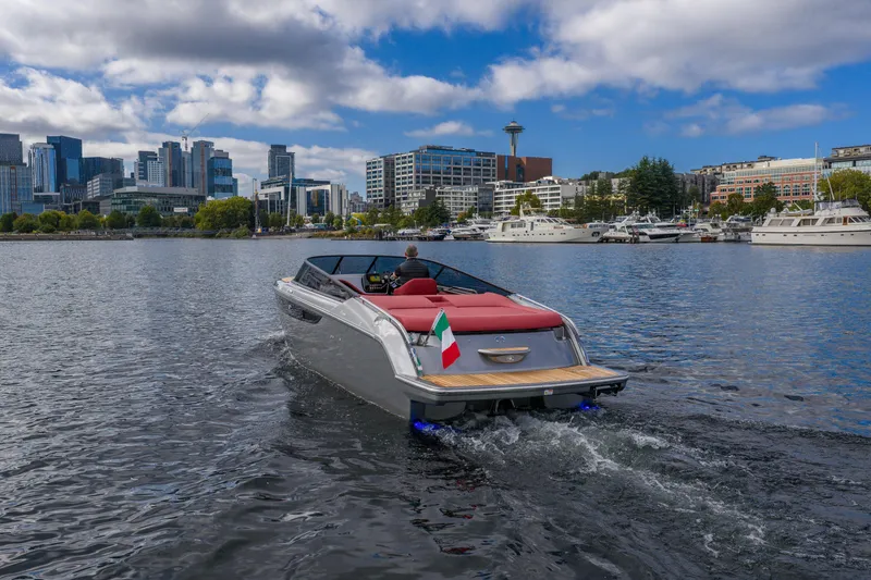 Slide: The Image of 2026 Cranchi E26 Classic boat cruising on a city waterfront with skyline view. - 16