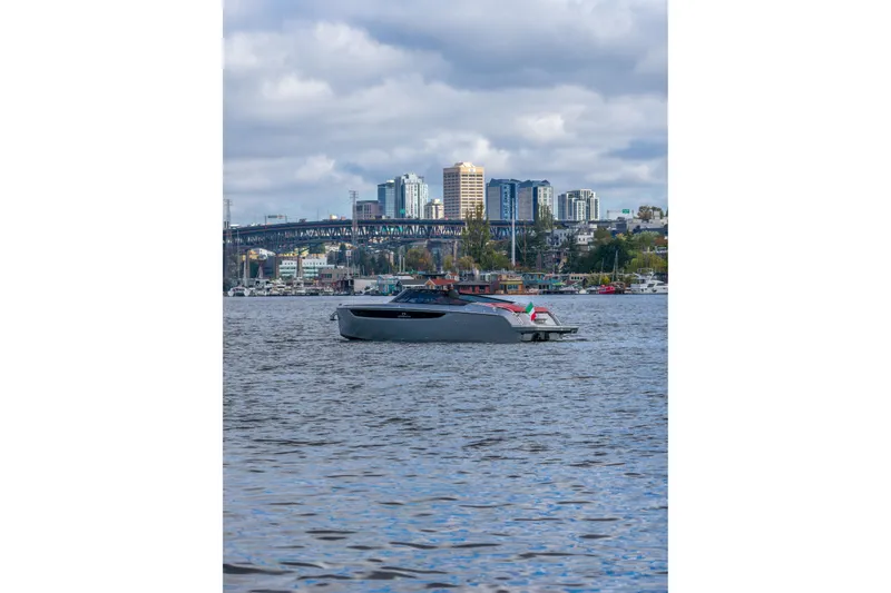 Slide: The Image of 2026 Cranchi E26 Classic boat on urban waterway with cityscape background. - 20