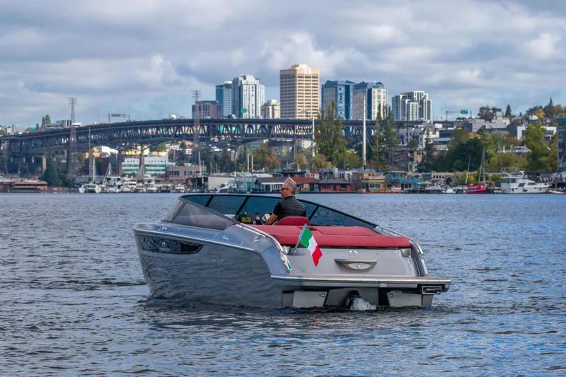 Slide: The Image of 2026 Cranchi E26 Classic boat cruising on a scenic urban waterway. - 21