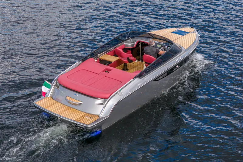 Slide: The Image of 2026 Cranchi E26 Classic boat cruising on water, featuring sleek design and red seating. - 23