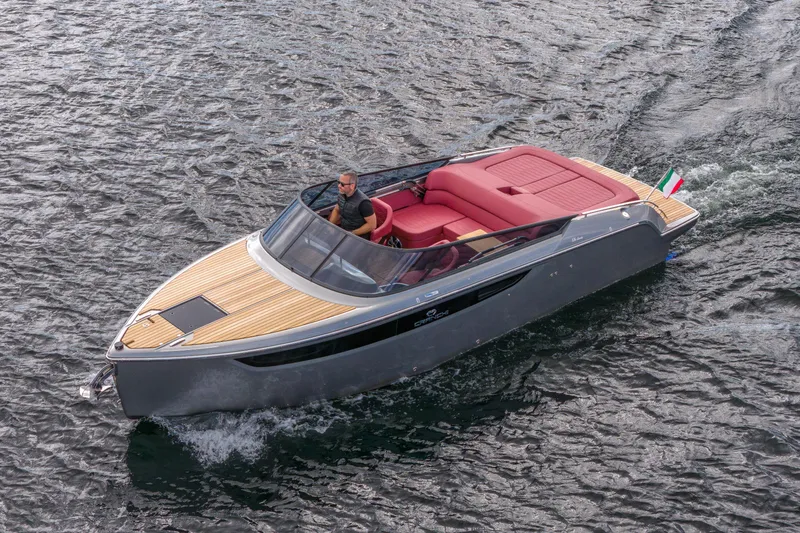 Slide: The Image of 2026 Cranchi E26 Classic boat cruising on water with sleek design and red seating. - 24