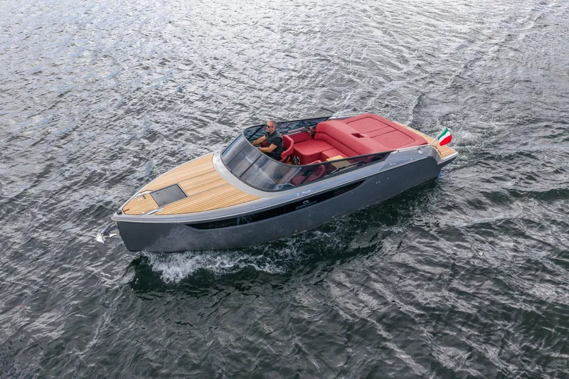 Slide: The Image of 2026 Cranchi E26 Classic boat cruising on water with sleek design and red seating. - 25