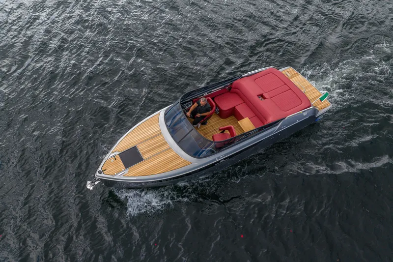 Slide: The Image of 2026 Cranchi E26 Classic boat with red interior cruising on water. - 26