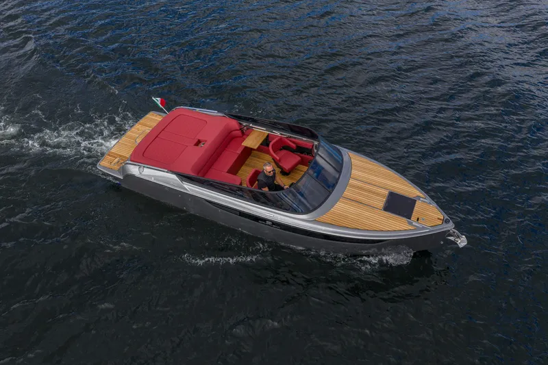 Slide: The Image of 2026 Cranchi E26 Classic boat cruising on open water, featuring sleek design and red seating. - 27