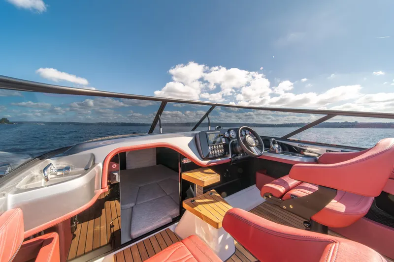 Slide: The Image of 2026 Cranchi E26 Classic yacht interior with red seats and modern dashboard on open water. - 33