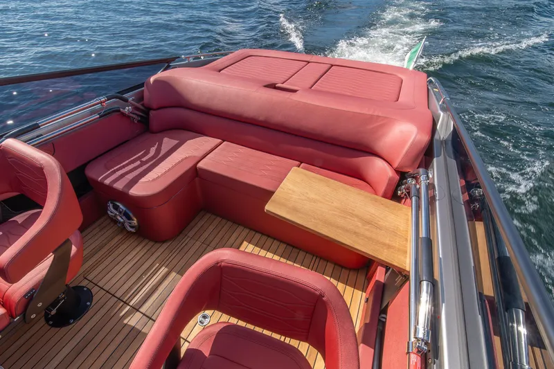Slide: The Image of 2026 Cranchi E26 Classic boat interior with red leather seating and wooden deck. - 36