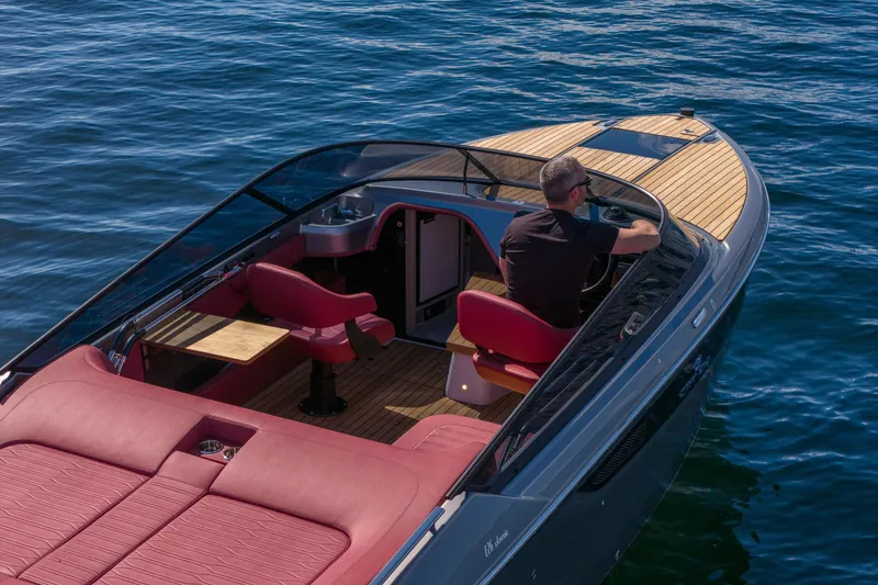 Slide: The Image of 2026 Cranchi E26 Classic boat with red seating, cruising on blue water. - 44