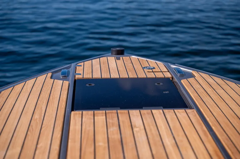 Slide: The Image of 2026 Cranchi E26 Classic boat deck with wooden finish on calm water. - 47