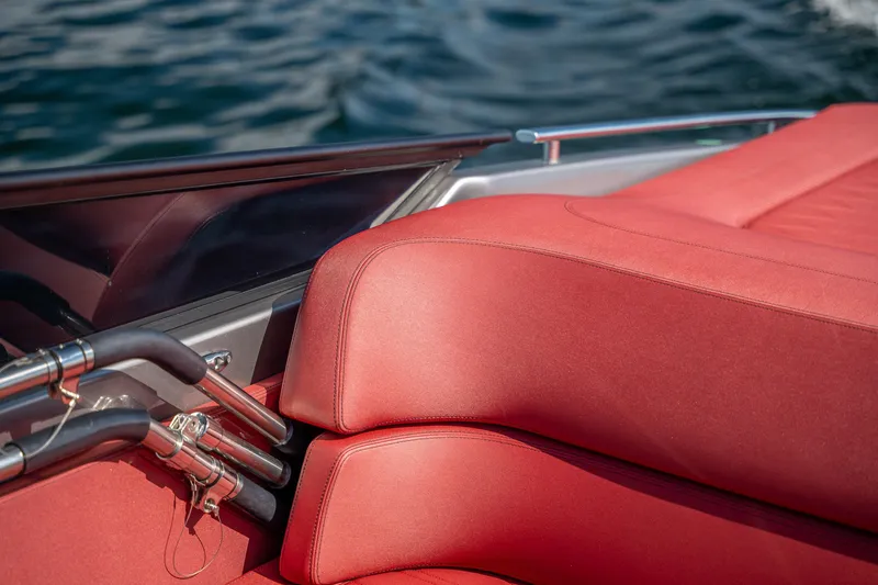 Slide: The Image of Red leather seating on 2026 Cranchi E26 Classic boat, with water in the background. - 48