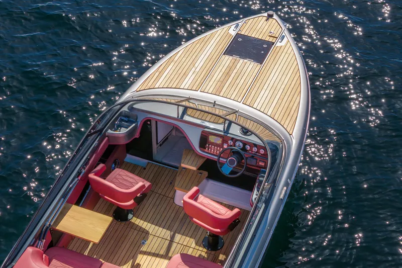 Slide: The Image of 2026 Cranchi E26 Classic boat with teak deck and red seats on sparkling water. - 6