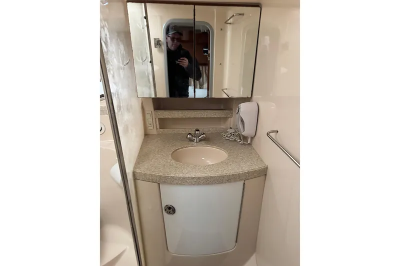 Slide: The Image of 2006 Regal Commodore 3560 IO bathroom with sink, mirror, and storage cabinet. - 12