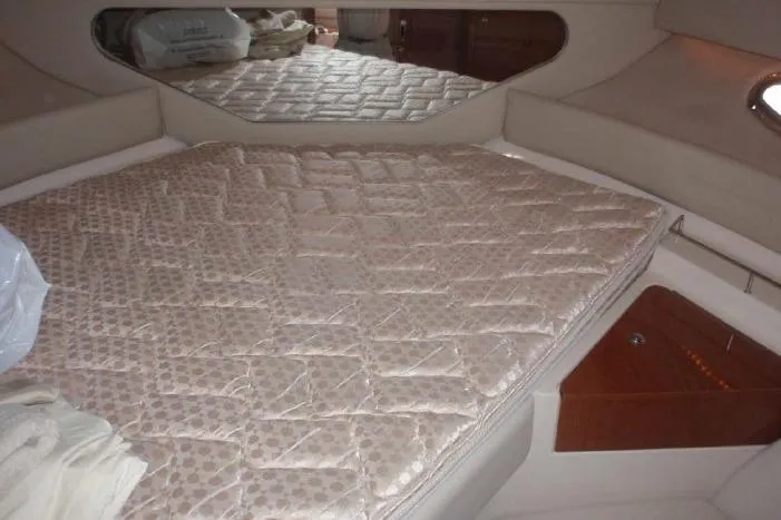 Slide: The Image of Interior cabin of 2006 Regal Commodore 3560 IO with quilted bed and wooden accents. - 16