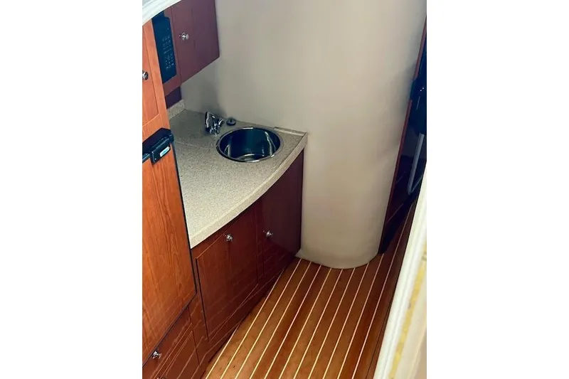 Slide: The Image of 2006 Regal Commodore 3560 IO yacht interior with wooden cabinetry and compact sink. - 21