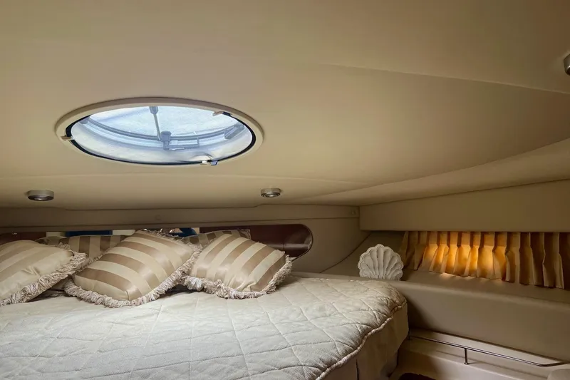 Slide: The Image of Cozy cabin interior of 2006 Regal Commodore 3560 IO with striped pillows and porthole. - 25