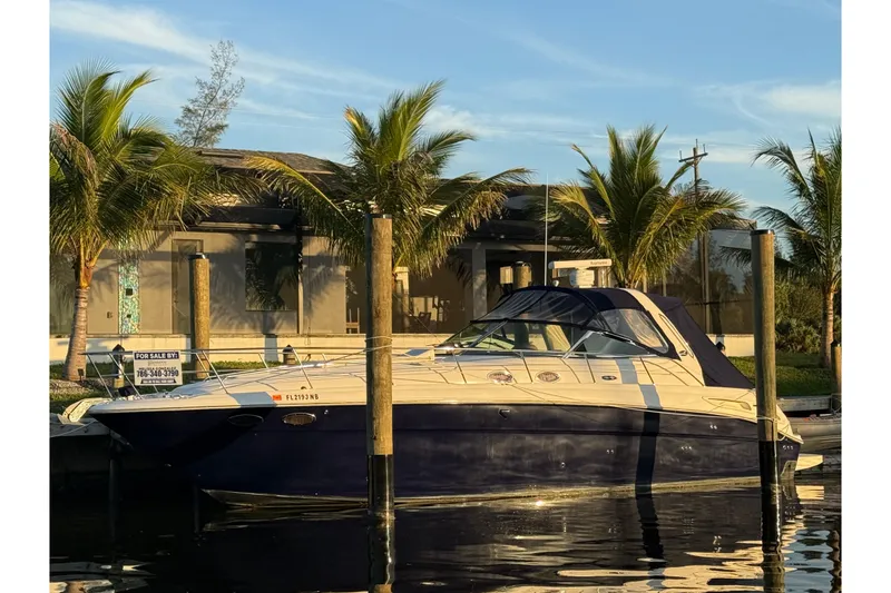 The Image of 2004 Sea Ray 380 Sundancer yacht docked, surrounded by palm trees, with a "For Sale" sign. - 0