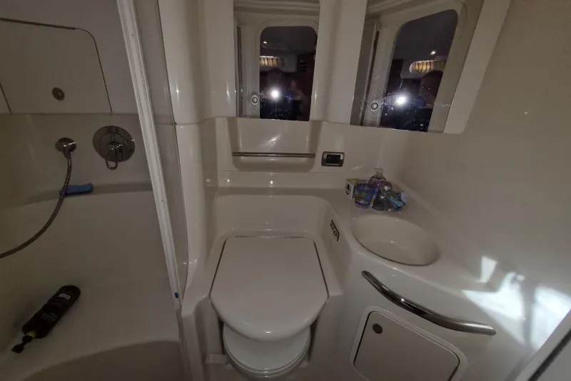 Slide: The Image of 2004 Sea Ray 380 Sundancer bathroom with toilet, sink, and shower area. - 19