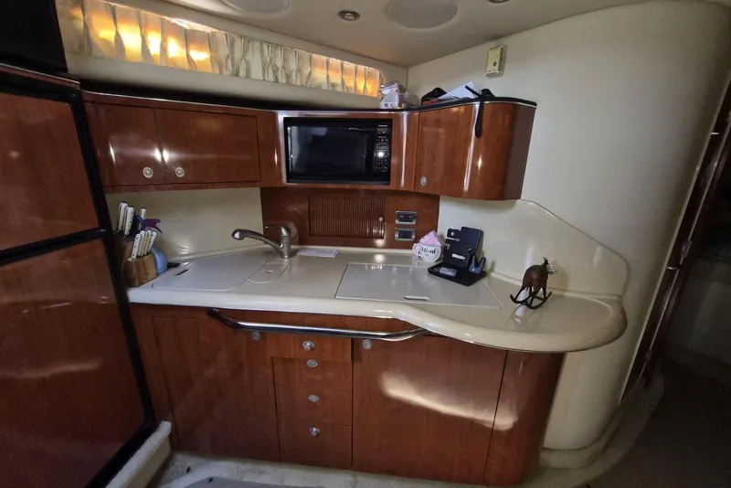 Slide: The Image of 2004 Sea Ray 380 Sundancer yacht kitchen with wood cabinets and modern appliances. - 22