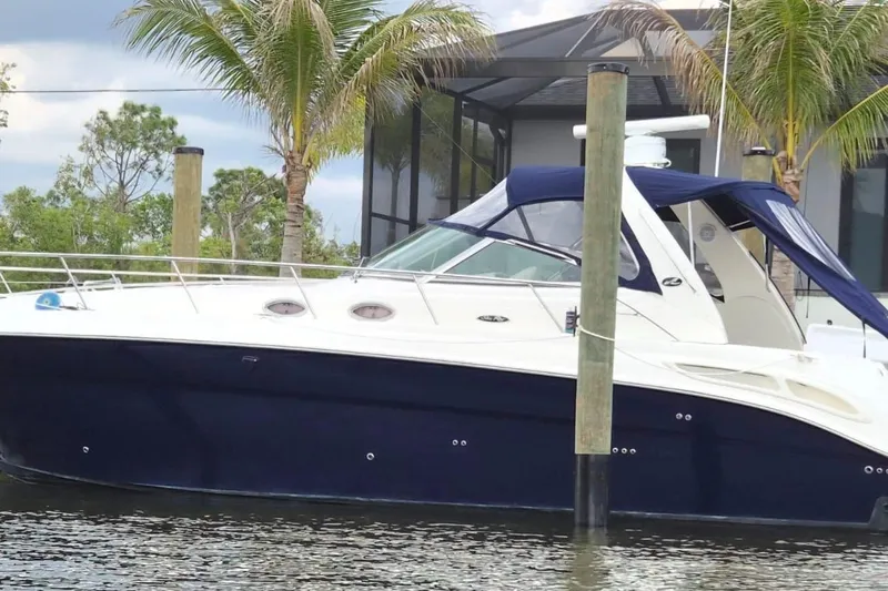 Slide: The Image of 2004 Sea Ray 380 Sundancer yacht docked near palm trees and modern house. - 32