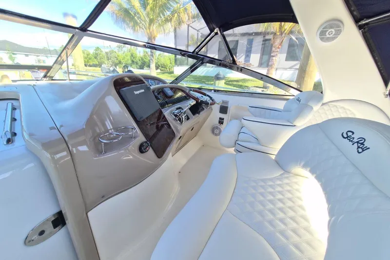 Slide: The Image of 2004 Sea Ray 380 Sundancer cockpit with luxurious white seating and modern dashboard. - 9