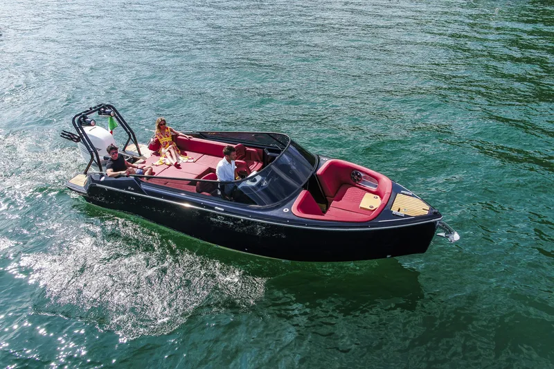 Slide: The Image of 2026 Cranchi E26 Rider boat cruising on clear water with passengers enjoying the ride. - 12