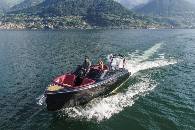 Slide: The Image of 2026 Cranchi E26 Rider cruising on a scenic lake with mountainous backdrop. - 16