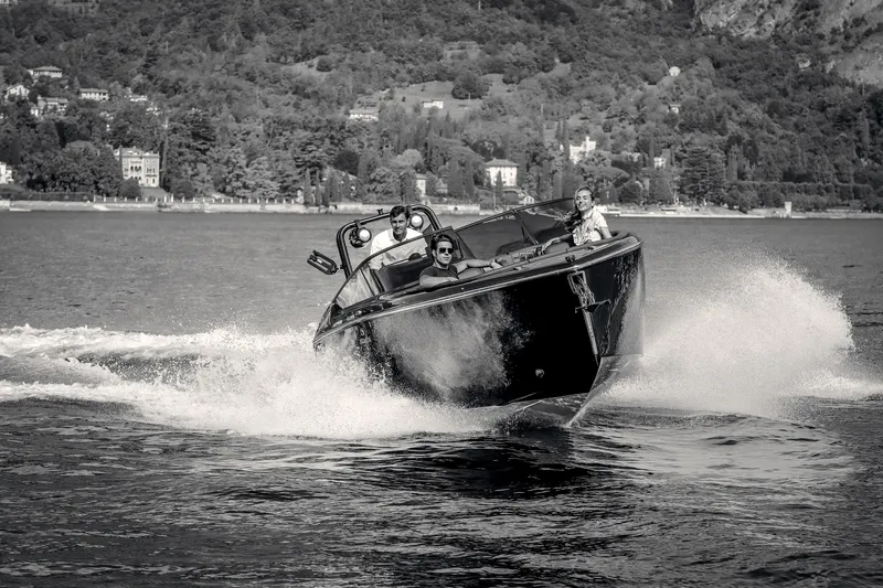 Slide: The Image of 2026 Cranchi E26 Rider speedboat cruising on a scenic lake with passengers. - 22