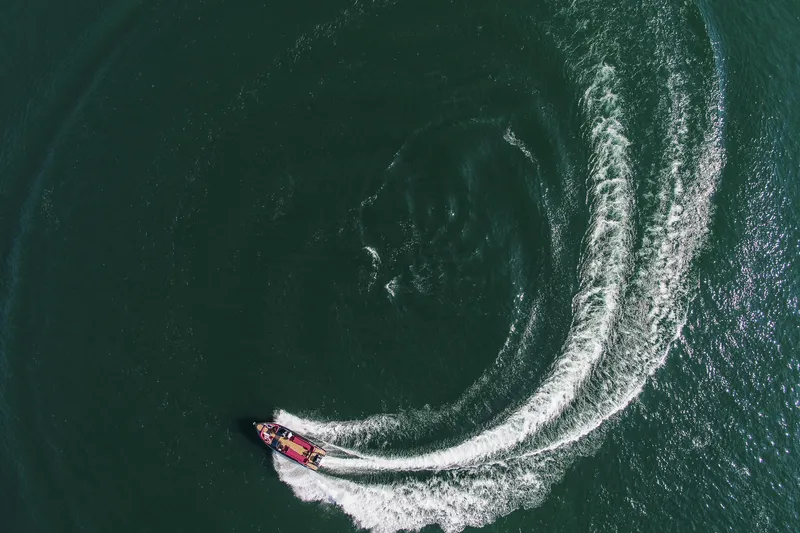 Slide: The Image of Aerial view of 2026 Cranchi E26 Rider making circular waves in the water. - 26