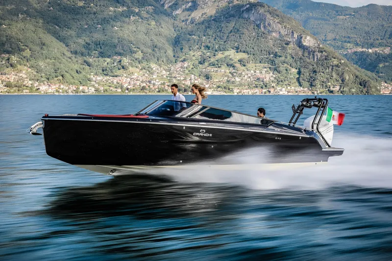 Slide: The Image of 2026 Cranchi E26 Rider speedboat cruising on a scenic lake with mountainous backdrop. - 3
