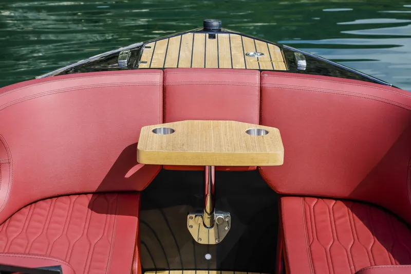 Slide: The Image of 2026 Cranchi E26 Rider boat interior with red seating and wooden table. - 30