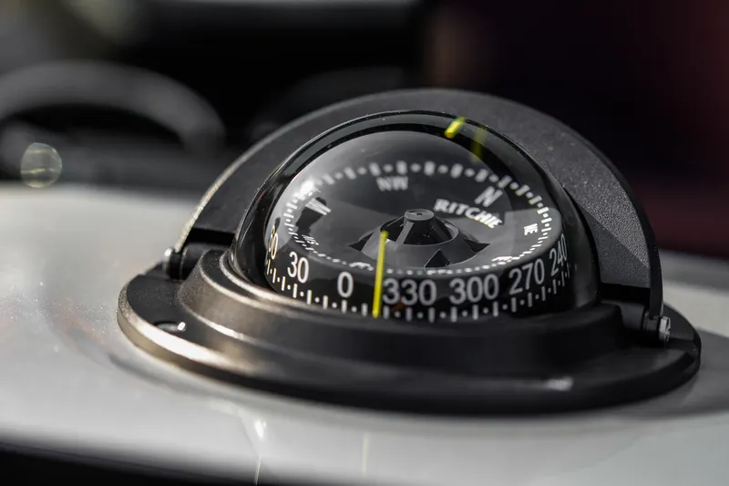 Slide: The Image of Close-up of a compass on the 2026 Cranchi E26 Rider boat dashboard. - 38