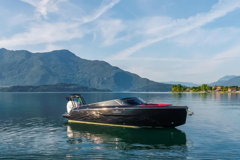 Slide: The Image of 2026 Cranchi E26 Rider boat on serene lake with mountain backdrop. - 4