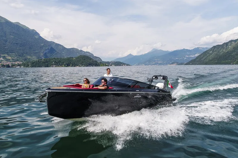 Slide: The Image of 2026 Cranchi E26 Rider cruising on a scenic lake with mountainous backdrop. - 41