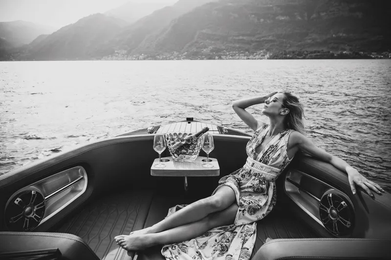 Slide: The Image of Woman relaxing on a 2026 Cranchi E26 Rider boat with scenic lake view. - 42