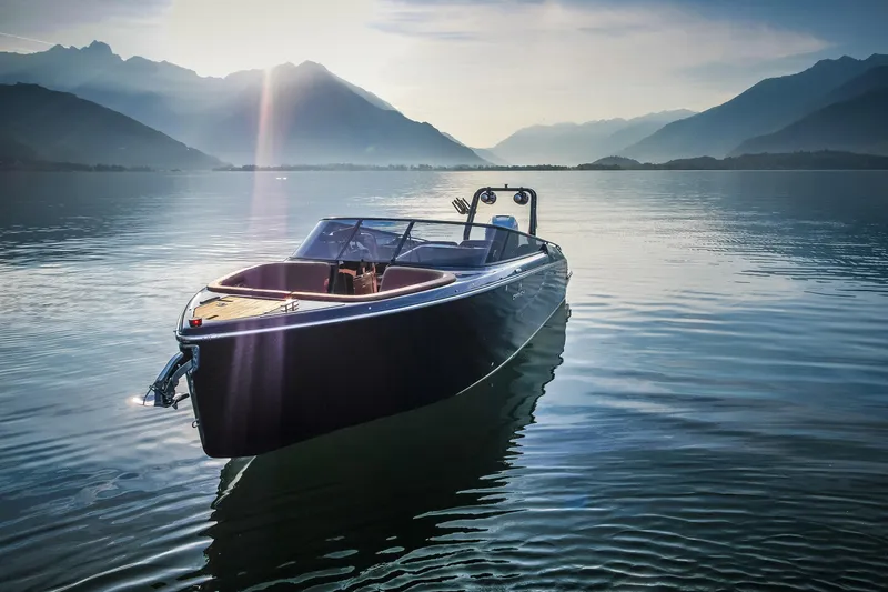 Slide: The Image of 2026 Cranchi E26 Rider boat on serene lake with mountain backdrop. - 5