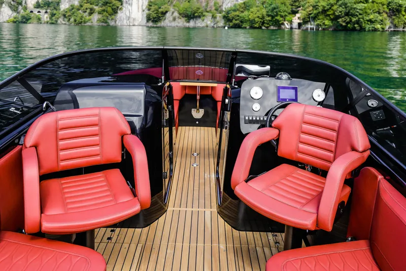 Slide: The Image of 2026 Cranchi E26 Rider boat interior with red seats and sleek dashboard design. - 7