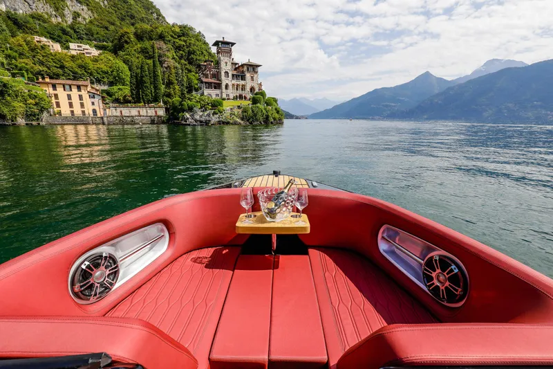 Slide: The Image of Luxurious 2026 Cranchi E26 Rider boat with red seating, cruising on a scenic lake. - 8