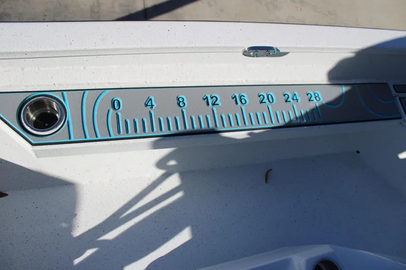 Slide: The Image of Ruler on 2026 Xpress H22B Bay boat deck with blue accents and cup holder. - 15