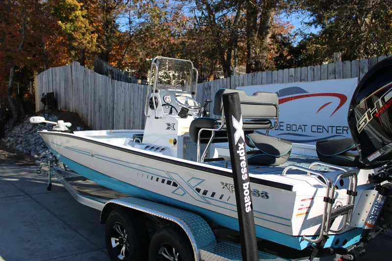Slide: The Image of 2026 Xpress H22B Bay boat on trailer, outdoor display with autumn foliage. - 3