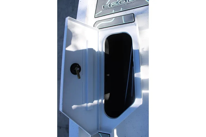Slide: The Image of 2026 Xpress H20B Bay boat storage compartment with open hatch and key. - 22