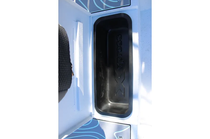 Slide: The Image of 2026 Xpress H20B Bay boat storage compartment with logo detail. - 23