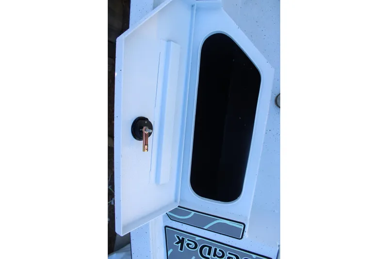 Slide: The Image of Open storage compartment with key in 2026 Xpress H20B Bay boat. - 24