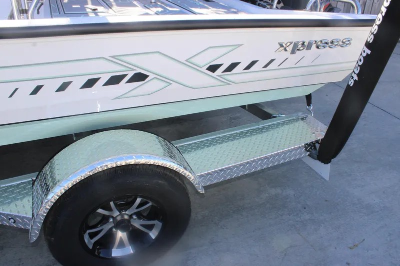 Slide: The Image of 2026 Xpress H20B Bay boat on a trailer with diamond plate fender. - 25
