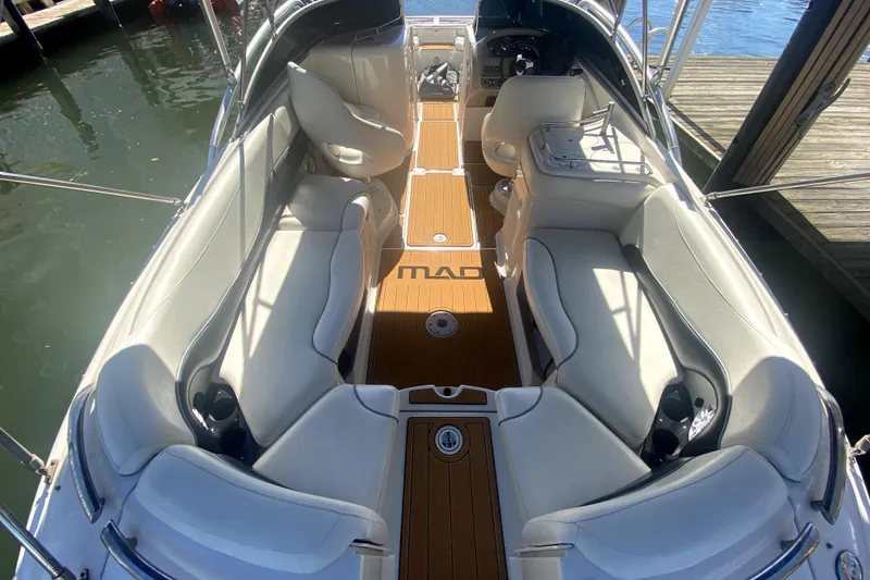 Slide: The Image of 2006 Monterey 263 Explorer Sport boat interior with white seating and wooden flooring. - 14