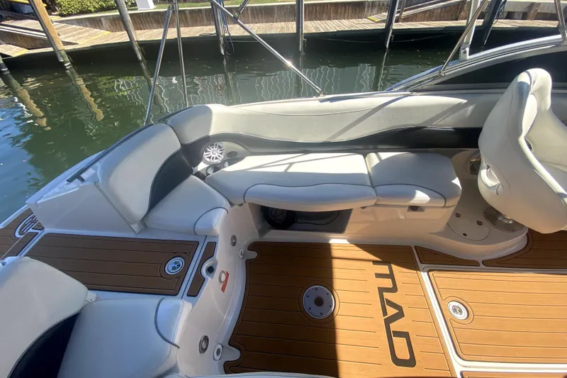 Slide: The Image of 2006 Monterey 263 Explorer Sport boat interior with cushioned seating and teak flooring. - 18