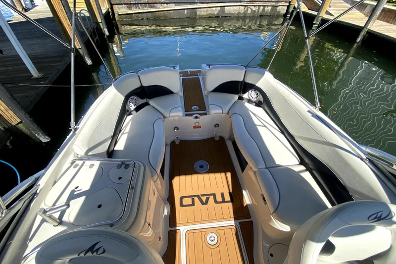 Slide: The Image of 2006 Monterey 263 Explorer Sport boat interior with white seating and wood flooring. - 20