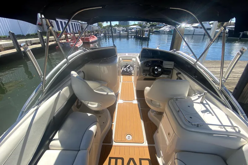 Slide: The Image of 2006 Monterey 263 Explorer Sport boat interior with seating and steering, docked at marina. - 21