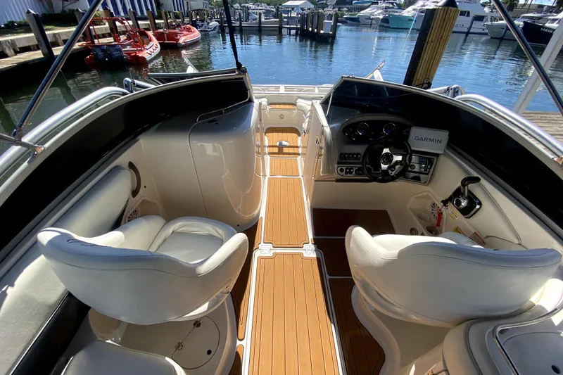 Slide: The Image of 2006 Monterey 263 Explorer Sport boat interior with helm, seating, and wood flooring. - 27